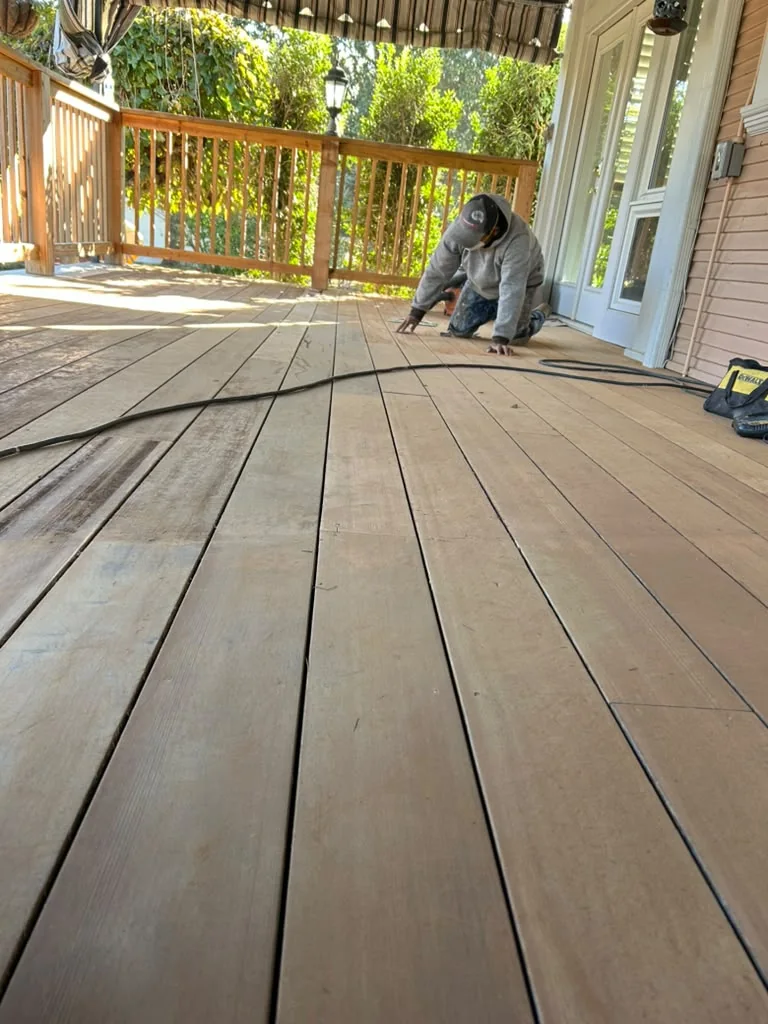 Worker preparing a wood deck before finishing